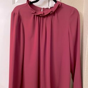 Maroon blouse with ruffled collar.